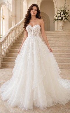 Robe de mariée bustier en dentelle florale, coupe trapèze, corset en tulle et traîne chapelle