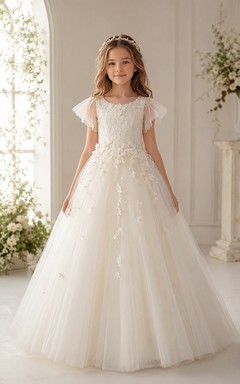 Vestido de Primera Comunión de corte A con apliques florales de tul color marfil y mangas con volantes.