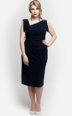 Vestido de punto ajustado hasta la rodilla con escote asimétrico y apliques.
