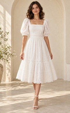 Vestido de novia romántico de corte A, largo hasta la rodilla, escote cuadrado, mangas abullonadas, volantes con ojales y detalles festoneados.