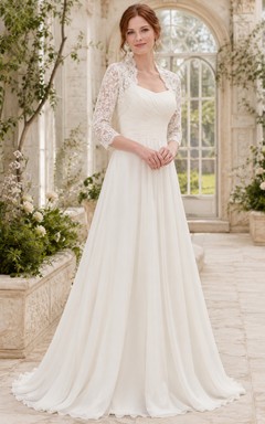 Robe de mariée en mousseline et dentelle, coupe trapèze, col rond, manches longues et traîne.