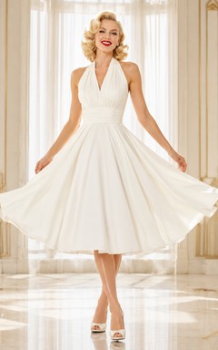 Vestido de cóctel blanco sin mangas con escote halter, de satén y gasa, con pliegues, espalda descubierta y corte en A, largo hasta la rodilla.