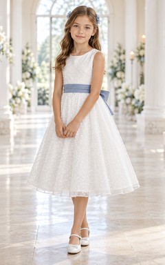 Vestido de niña de flores blanco de corte A, sin mangas, con lunares y fajín azul, hasta la rodilla.