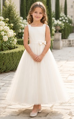 Robe de demoiselle d'honneur blanche sans manches en tulle, coupe trapèze, encolure carrée et jupe mi-longue ornée de détails floraux.