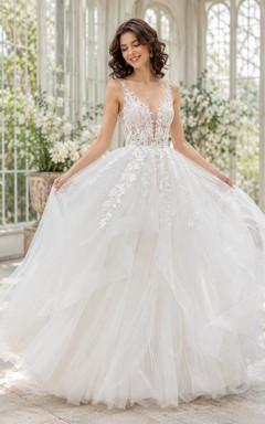 Vestido de novia romántico de tul y encaje con escote corazón y cola de capilla.
