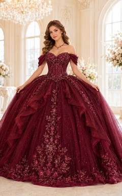 Vestido de quinceañera color borgoña, de tul y encaje, con hombros descubiertos, mangas abullonadas, volantes y cola de capilla. Lujoso.