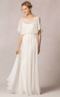 Robe de mariée bohème en mousseline de soie ornée d'appliqués et de plis, coupe fourreau, col rond, manches bouffantes et manches bouffantes.