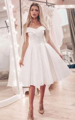 Robe de mariée courte en satin, simple, épaules dénudées, bustier croisé, coupe empire, longueur genou.