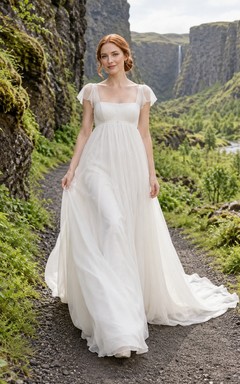 Vestido de novia de organza con escote cuadrado estilo imperio, mangas cortas con volantes y cola de corte.