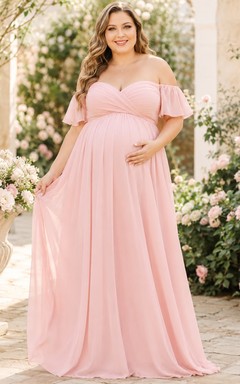 Vestido de maternidad romántico de gasa color rosa empolvado con hombros descubiertos, mangas con volantes y corte imperio, largo hasta el suelo.