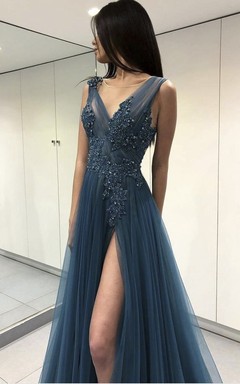 Vestido largo hasta el suelo con escote en V, tul etéreo, abertura frontal, apliques y abalorios.