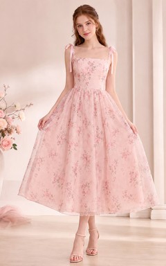 Robe de soirée en tulle rose poudré à encolure carrée sans manches et longueur thé, ornée de fleurs et d'un col carré.