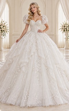 Vestido de novia de corte princesa con escote corazón, mangas abullonadas, cascadas de tul con cuentas y cola de corte.