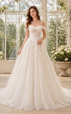Robe de mariée champêtre en dentelle et tulle, bretelles cœur, sans manches, coupe trapèze, traîne chapelle, applications florales.