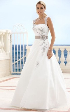 Robe de mariée longue en satin fleuri drapé à bretelles, ornée d'un ruban et d'une découpe en forme de goutte, avec décolleté en V.