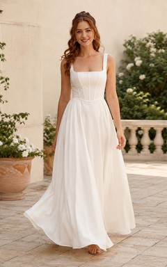 Robe de mariée longue en mousseline, col carré, sans manches, corsage à coutures apparentes, taille naturelle, dos nu à bretelles, coupe trapèze.