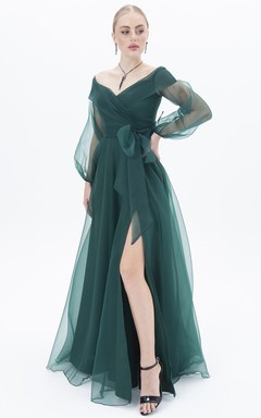 Robe de soirée élégante en mousseline de soie, coupe trapèze, manches longues, fermeture éclair et fente sur le devant.