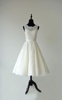 Robe en dentelle sans manches, coupe trapèze, longueur thé, dos nu en V et ceinture en satin.