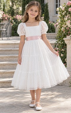 Vestido de niña de flores blanco de corte A con escote cuadrado, mangas abullonadas y volantes rosas, largo hasta la rodilla.