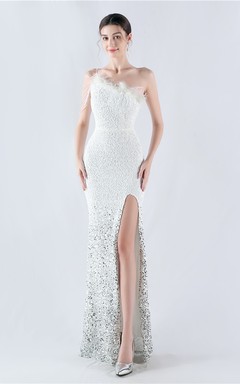 Robe de soirée longue à une épaule, ornée de plumes d'autruche, de perles et de sequins, avec col asymétrique et fente haute.