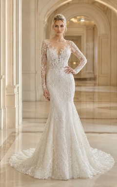 Robe de mariée sirène en dentelle harmonieuse, décolleté en V profond, manches longues, traîne chapelle, applications florales, idéale pour un mariage à destination.