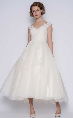 Robe de bal élégante en organza, manches courtes, longueur cheville, ornée de fleurs.