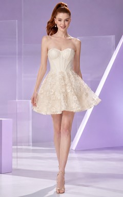 Robe de cocktail courte contemporaine ivoire sans bretelles, corset à fleurs et perles, coupe trapèze, idéale pour un bal de fin d'année.