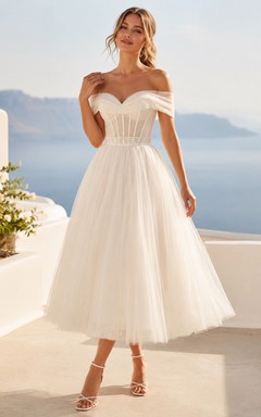 Vestido de novia romántico de tul con corsé y hombros descubiertos, largo hasta la rodilla, para una boda en la playa.