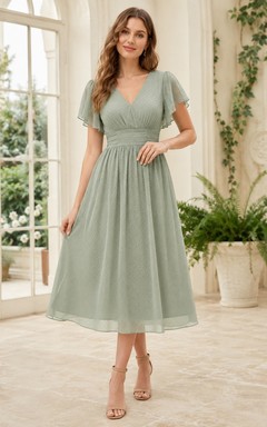 Robe d'invitée décontractée en mousseline sauge, col V, manches pétales, coupe trapèze, longueur thé, idéale pour un jardin.