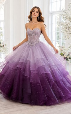 Vestido de princesa de quinceañera sin tirantes, con capas de tul brillante y efecto degradado en tonos lila y ciruela