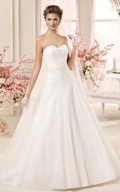 Brautkleid in A-Linie mit herzförmigem Ausschnitt, Perlenbesatz, Faltenrock und Schnürung am Rücken.