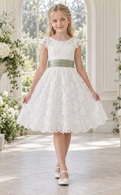 Vestido de niña de flores vintage blanco con estampado floral, corte en A, mangas cortas de encaje y fajín color salvia, hasta la rodilla.
