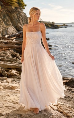 Spaghettiträger-Kleid aus rosafarbenem Tüll für eine romantische Hochzeit an der felsigen Küste