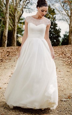 Robe de mariée vaporeuse en mousseline de soie à dentelle bateau, coupe trapèze, longueur au sol, dos nu plongeant et ruban.