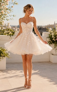Robe de mariée mini en tulle à bretelles spaghetti et dentelle florale, décolleté cœur, style romantique.