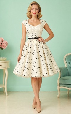 Vestido de cóctel vintage de los años 50, de satén, color crema, con estampado de lunares, escote corazón, mangas cortas, corte en A y largo hasta la rodilla.