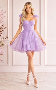Robe de cocktail romantique en tulle lavande, décolleté cœur, coupe trapèze, bretelles ruban courtes, idéale pour un bal de fin d'année.