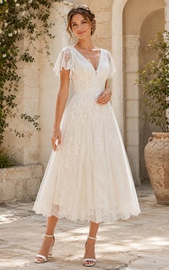 Vestido de novia bohemio de encaje con escote en V, mangas con volantes y largo hasta la rodilla, ideal para bodas campestres en jardines.
