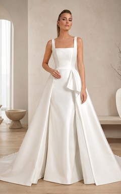 Robe de bal sans manches en satin ornée d'un col carré et d'une traîne cathédrale, ornée d'un nœud sculptural, pour un mariage de destination.