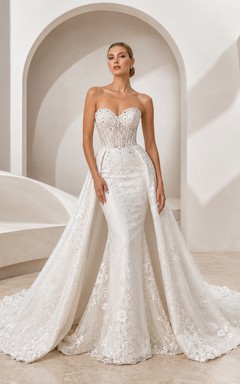 Robe de mariée sirène bustier en dentelle délicate, décolleté cœur et traîne chapelle, style godet, idéale pour un mariage au bord d'un lac.