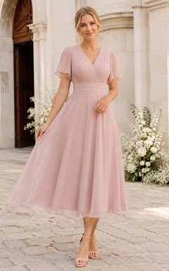 Vestido de madre de gasa plisada de corte A, largo hasta la rodilla, con escote en V y mangas cortas con volantes, color rosa empolvado.