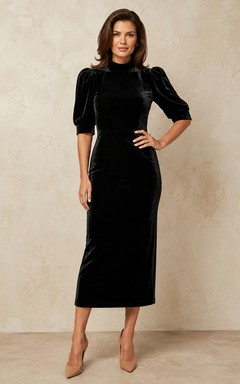 Vestido tubo de terciopelo negro con escote cuadrado y mangas tres cuartos.