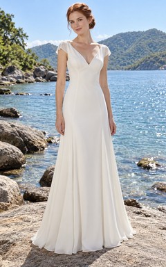 Vestido de novia sencillo de gasa con escote en V, mangas cortas y espalda descubierta.