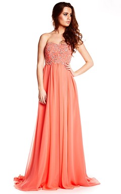 Robe de bal bustier en mousseline perlée avec traîne.