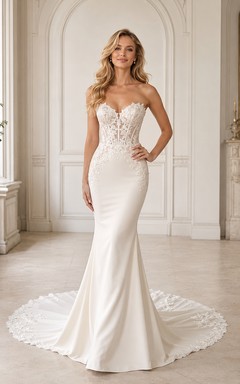 Robe de mariée sirène en satin et dentelle vaporeux, bustier cœur sans manches, traîne chapelle, ornée d'appliqués floraux.