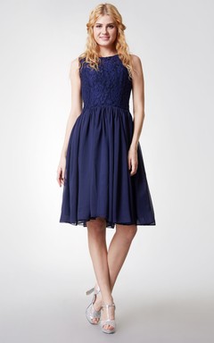 Robe glamour en mousseline plissée, longueur genou, col rond et ceinture en satin.