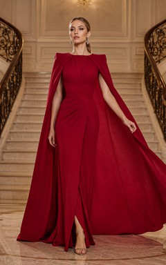 Vestido de noche rojo de corte A con mangas tipo capa, escote barco y falda larga con abertura frontal.