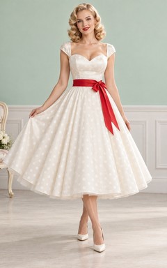 Robe trapèze rouge à pois style rockabilly vintage, avec ceinture et manches courtes.