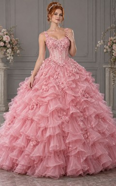 Vestido de novia de gala color rosa empolvado con escote redondo y tirantes florales, adornado con cascadas de organza cubiertas de rosas.