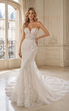 Robe de mariée sirène bustier en dentelle vaporeuse, ornée d'appliqués floraux et d'une traîne chapelle.